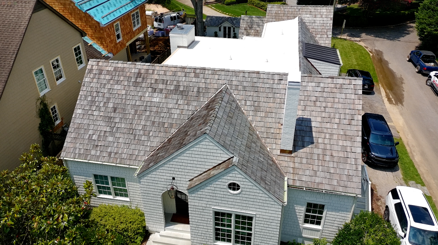 Finished Birmingham home with cedar shake, standing-seam metal, and a white low-slope membrane on one roof